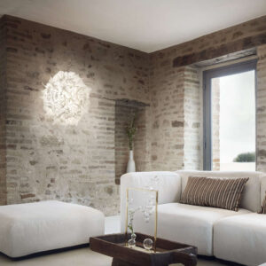 Аплик SLAMP Veli Foliage в интериор с каменни стени и естествени материали.