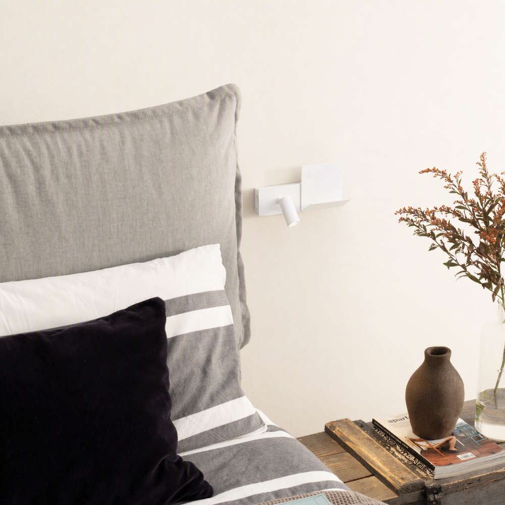 Апликът Ideal Lux Komodo-1 AP 291789 в бял цвят до легло, с рафт вдясно от подвижната глава