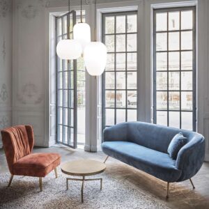 Три пендела от серията Ideal Lux Umile над маса в дневна, като Umile-1 SP1 314969 е широкият заоблен модел вляво