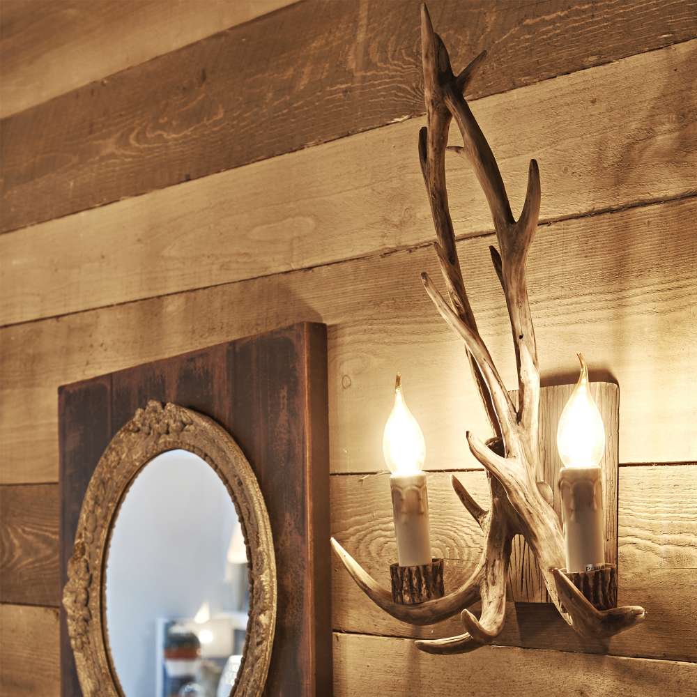 Близък изглед към аплика Ideal Lux Chalet AP02 115511 с декоративни рога от смола върху дървена стена