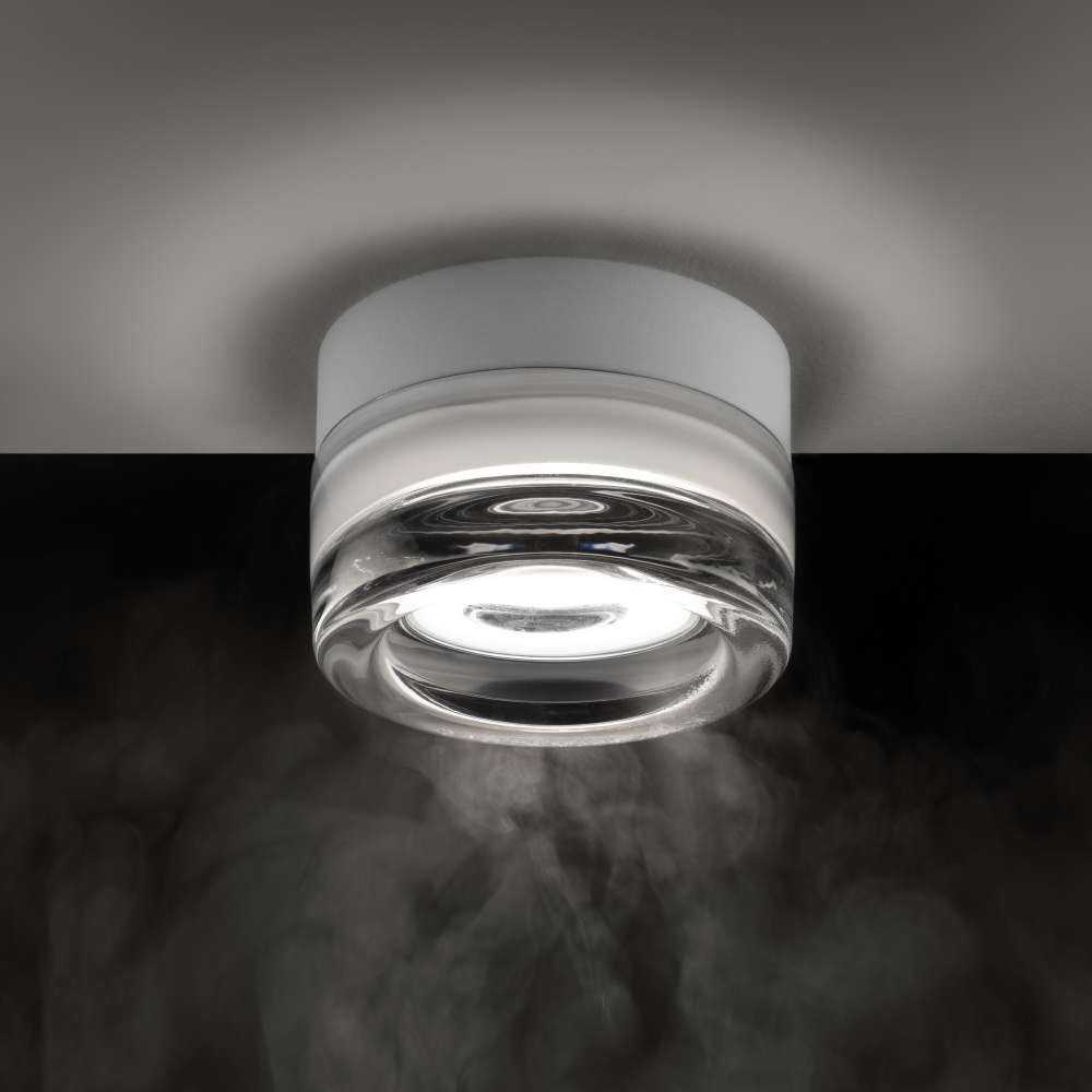 Ideal Lux Lolly AP1 Trasparente 354651 с бяла основа и прозрачно стъкло е показан отблизо включен на таван