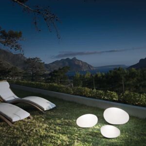 Градинските лампи Sasso с дължини 25, 33 и 41 см, включително Ideal Lux Sasso PT1 D41 161778, светят върху тревата до шезлонги