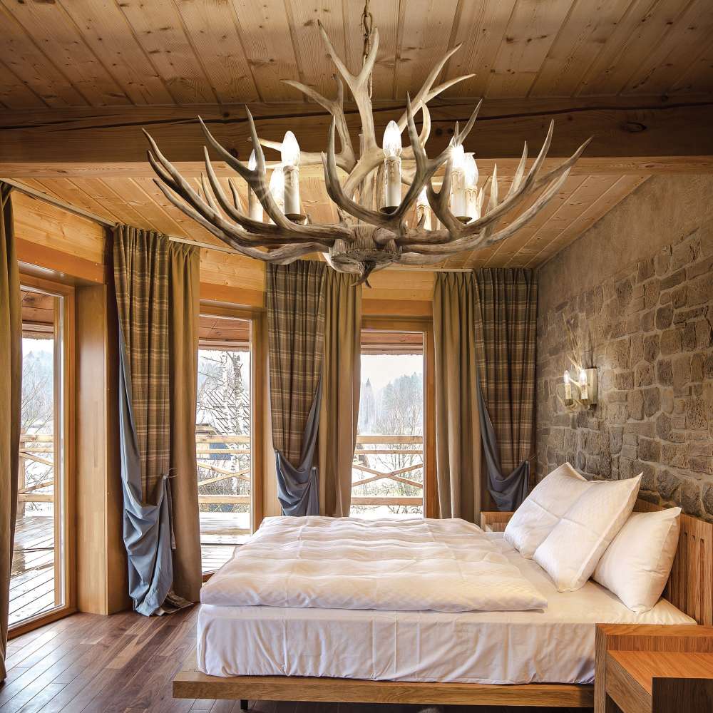 Полилей Ideal Lux Chalet SP08 115504 с осем светлинни източника в спалня с дървен таван
